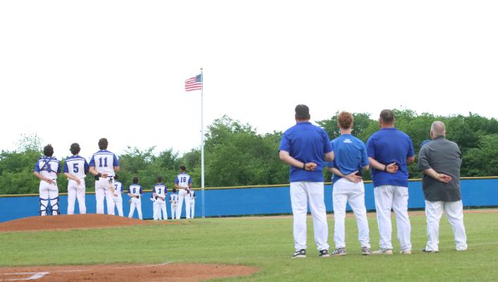 Wills Point Tiger players and coaches stand at attention for the playing of the national anthem ahead of the team’s district matchup with Kaufman. Photo by Regina DeDominicis